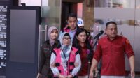 Dua dari empat tersangka korupsi tata niaga emas PT Antam menggunakan rompi tahanan keluar dari ruang pemeriksaan Kejaksaan Agung, Jakarta