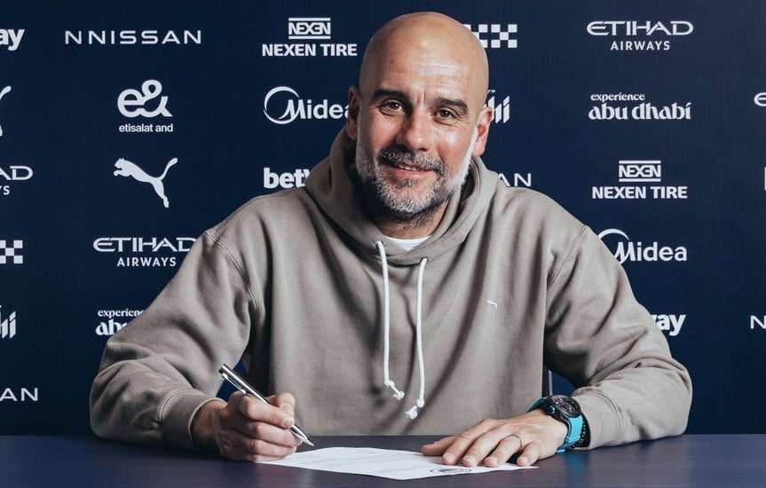 Pep Guardiola saat menandatangani kontrak baru bersama Manchester City