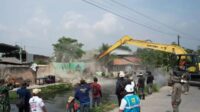 Alat berat dikerahkan petugas gabungan saat penertiban bangunan liar di sepanjang Bantaran Saluran Sekunder Sukatani Kecamatan Cikarang Utara, Kabupaten Bekasi